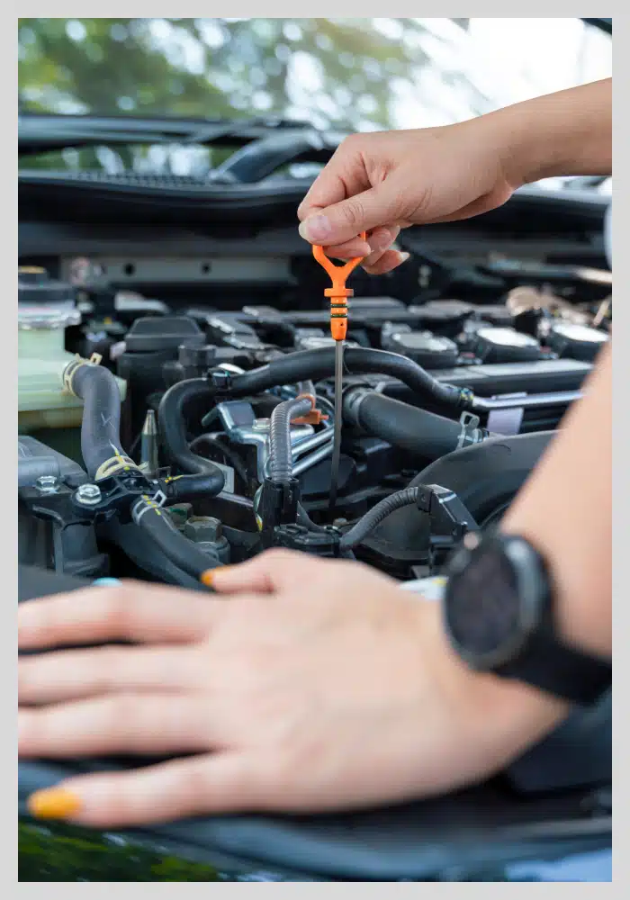 an image of a person checking a vehicle's engine oil